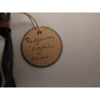 Circular label with metal outline tied to object